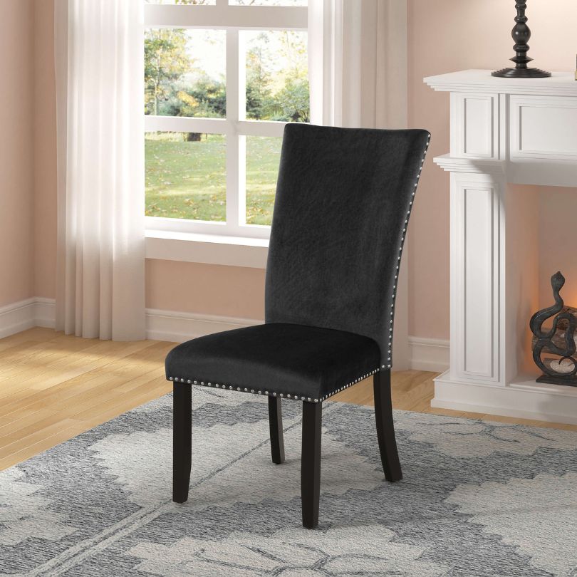 Stylish black velvet dining chair set placed around a modern dining table.
