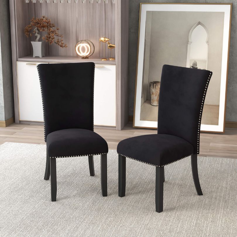 Elegant black velvet armless dining chair set showcasing nailhead trim from the side.