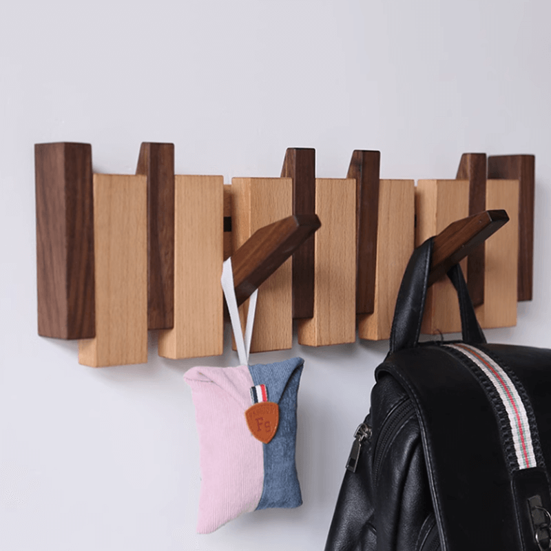 Black walnut wall-mounted coat rack in a stylish entryway, neatly organized.