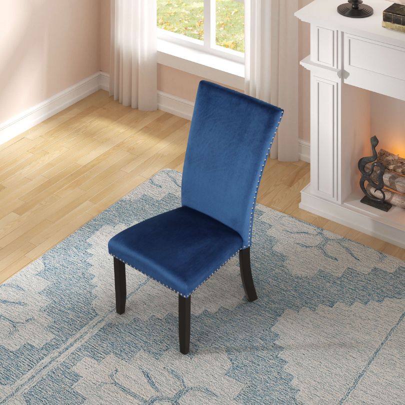 Rubber wood legs of blue velvet dining chair showcasing stability and design.