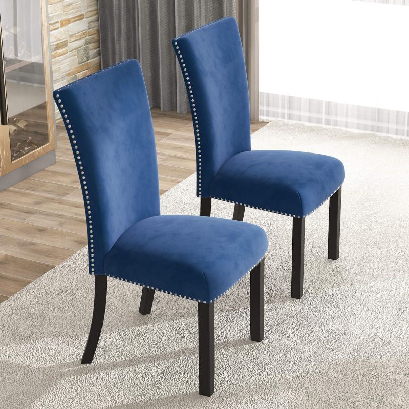 Close-up of nailhead trim on blue velvet upholstered chair, highlighting craftsmanship.