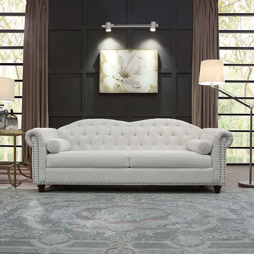 Luxury white Chesterfield sofa in modern living room setting, showcasing button tufting and nailhead trim.