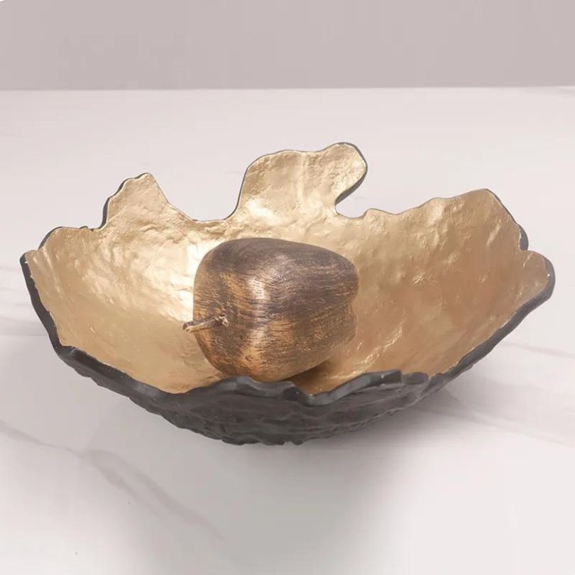 Elegant black and gold fruit storage plate displayed in a dining room