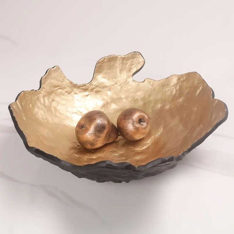 Golden fruit bowl on a kitchen counter, holding fresh fruits