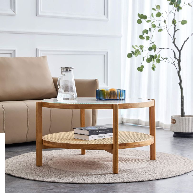 Modern circular glass coffee table with a rattan base, showcasing its elegant design.