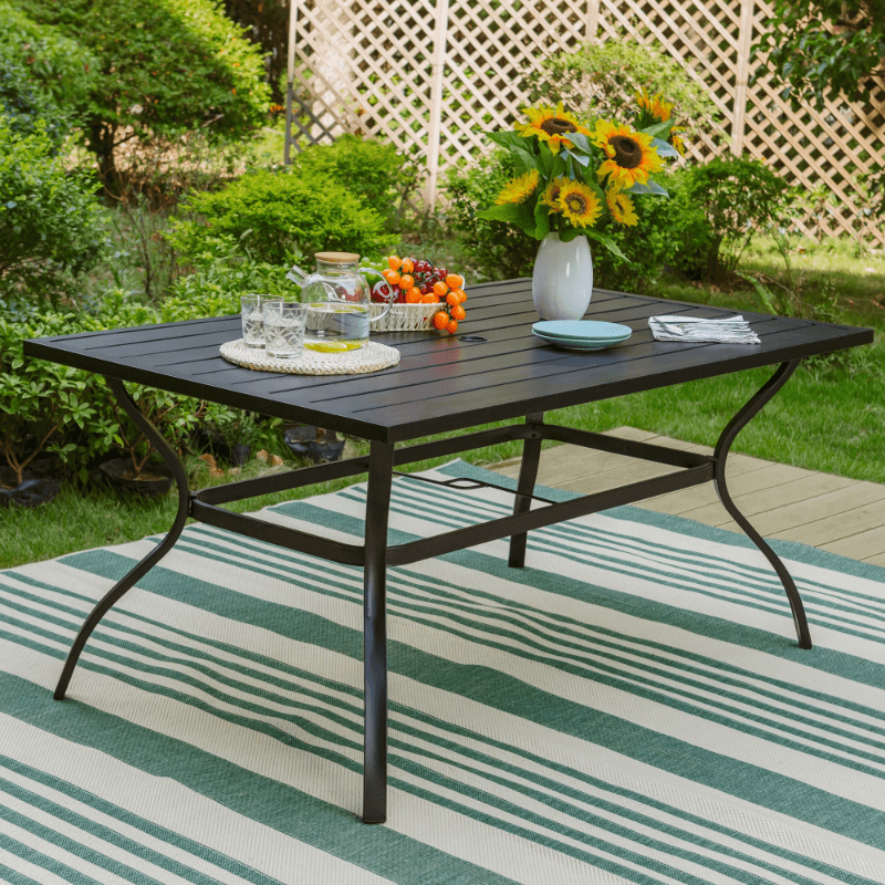 Elegant rectangular patio table set up for an outdoor dinner with six chairs around it.