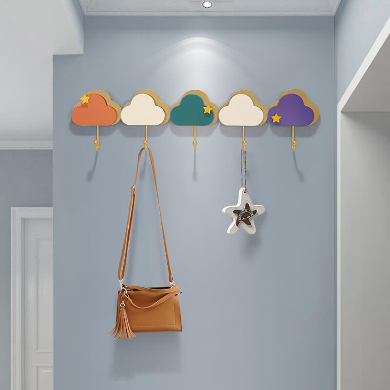 Cloud-shaped coat rack with hooks mounted on a wall in a stylish modern entryway.
