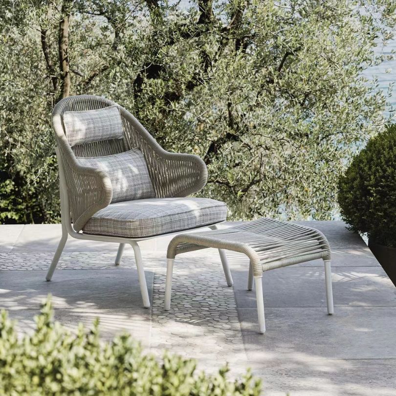 Modern outdoor leisure chair with footstool in a stylish patio setting.