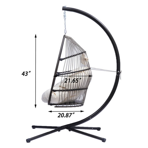 Trendy rattan swing hammock chair in a garden setting with blue cushion