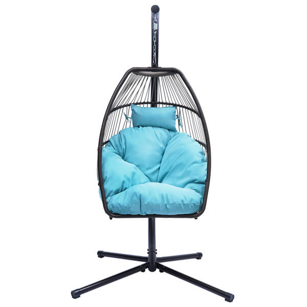 Trendy rattan swing hammock chair in a garden setting with blue cushion