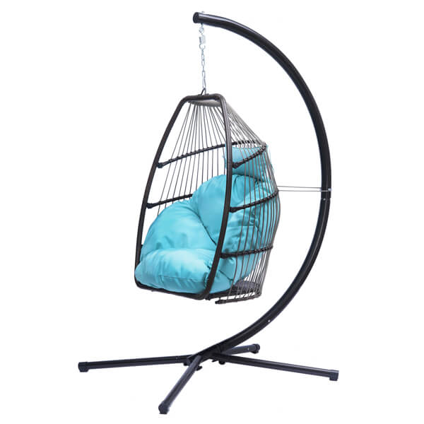 Trendy rattan swing hammock chair in a garden setting with blue cushion