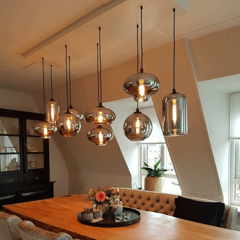 Modern smoked glass bubble pendant lights hanging in a stylish dining room.