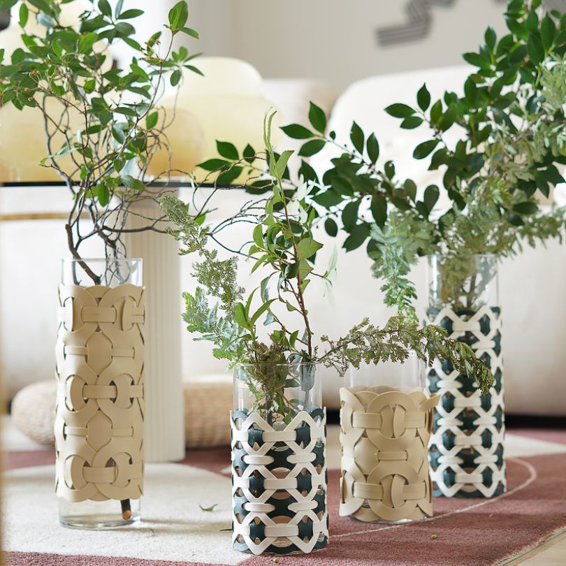 Elegant leather wrapped glass vase in a bright living room setting.