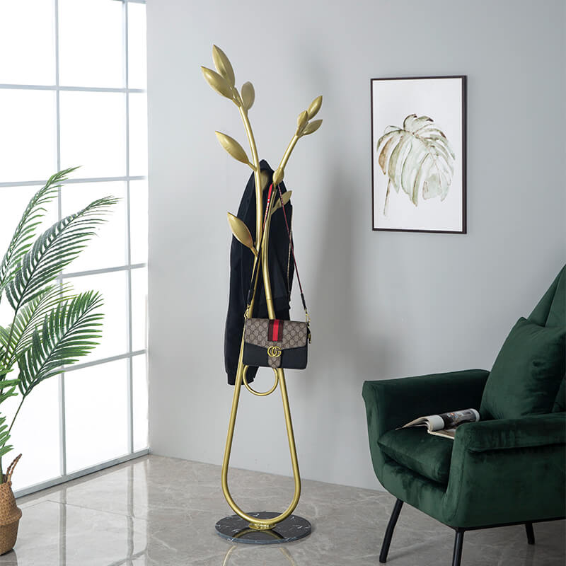 Gold coat rack positioned near the entrance, demonstrating its modern aesthetic and functional design.