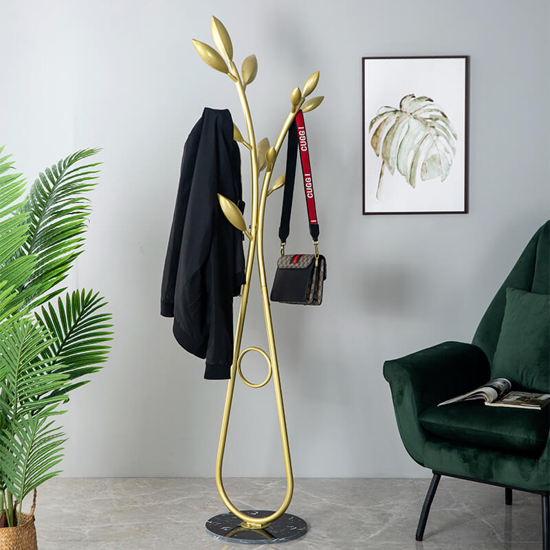 Freestanding gold coat stand with hooks in a bright hallway, perfect for organizing coats and accessories.