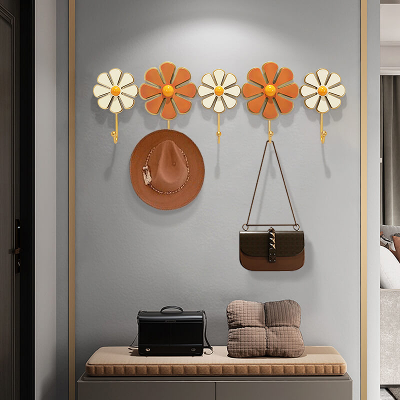 Front view of Daisy modern coat rack mounted in a hallway with coats and scarves