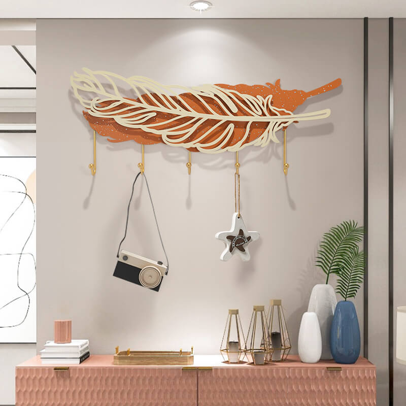 Close-up of the gold-finished metal hooks on the Elegant Feather Wall Hook Rack.