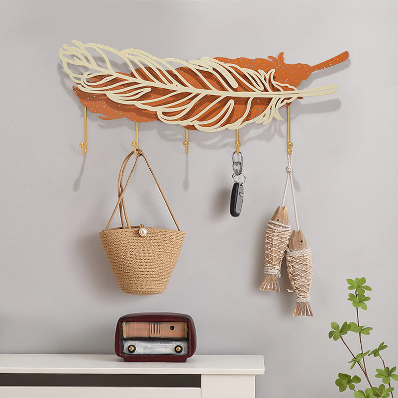 Close-up of the gold-finished metal hooks on the Elegant Feather Wall Hook Rack.