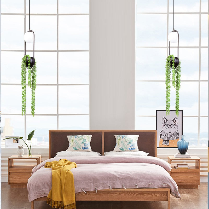 View of the pendant light installed in a cozy bedroom corner with vibrant plants.