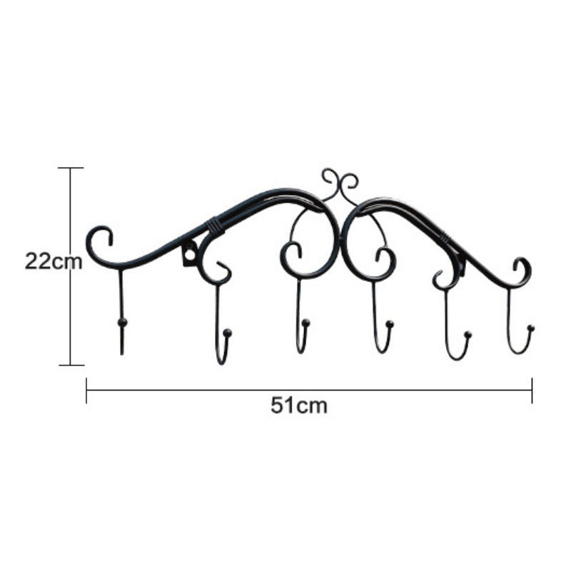 Angled view of the RetroWall™ metal coat rack in gold finish mounted on an entryway wall with coats hanging