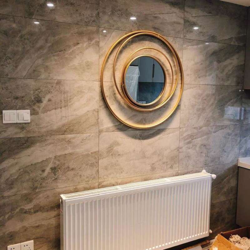 Elegant European Gold Circle Mirror hanging in a stylish living room with natural light.