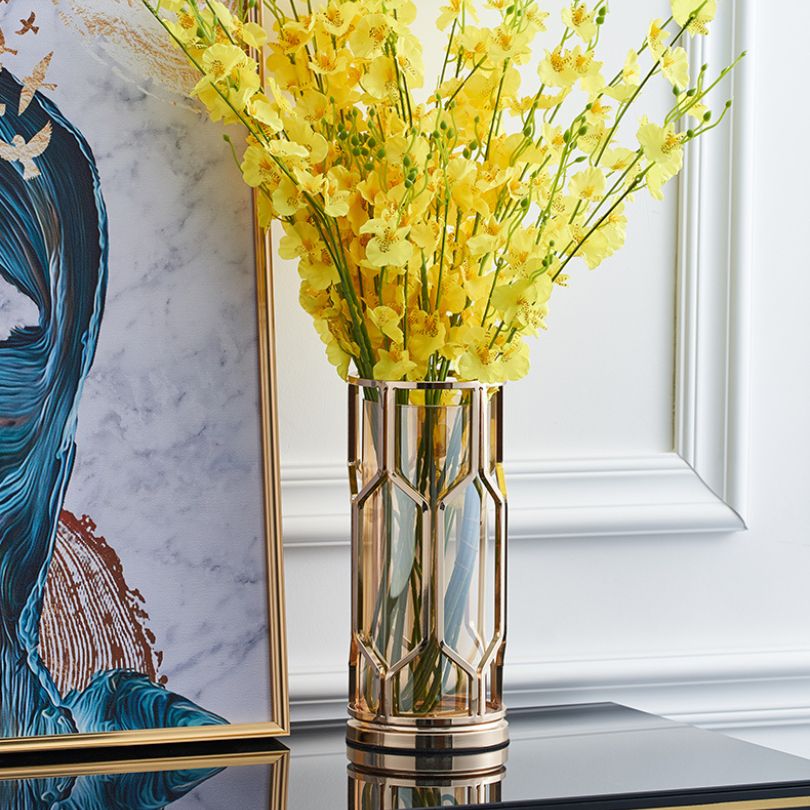 Close-up of the transparent golden glass vase highlighting its luxurious finish.