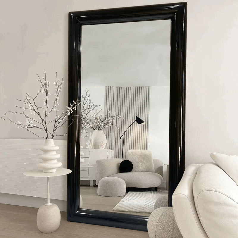 Elegant European style black frame floor mirror leaning against a wall showcasing its sleek design.