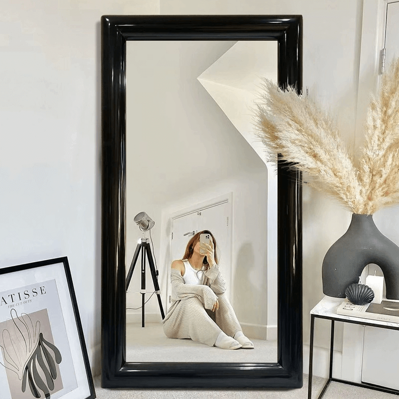 High-quality full-length mirror reflecting natural light in a cozy living room setting.
