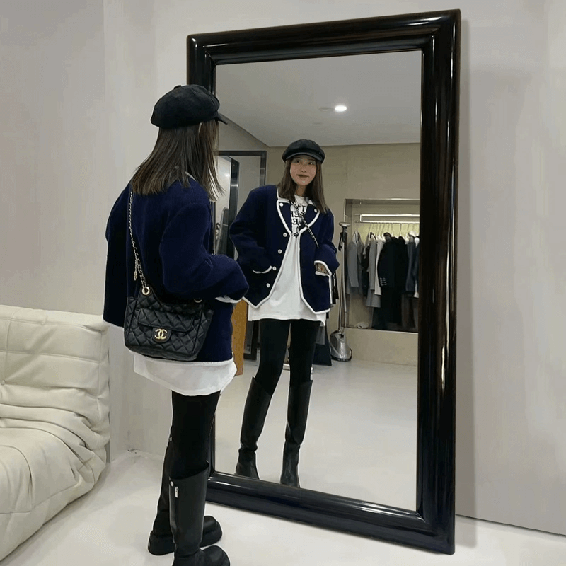 High-quality full-length mirror reflecting natural light in a cozy living room setting.