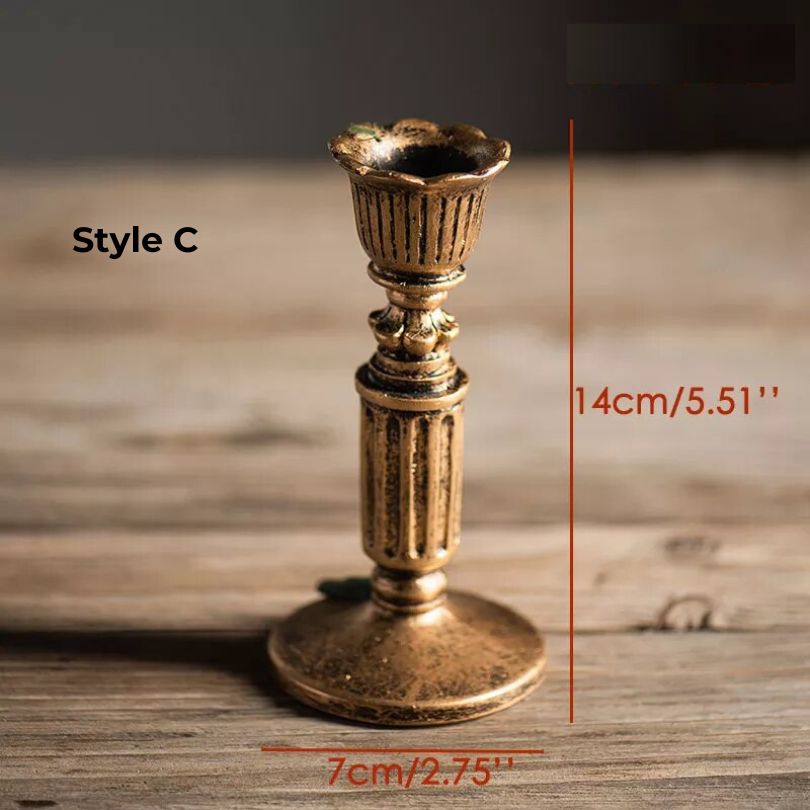 Multiple sizes of rustic gold candle holders arranged on a tabletop.