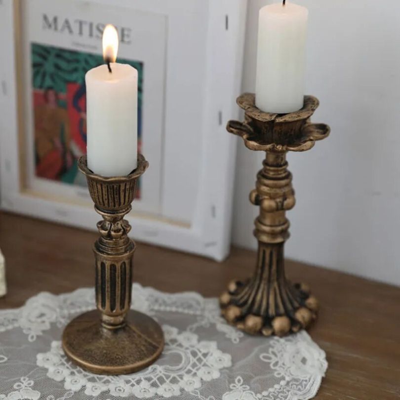 Multiple sizes of rustic gold candle holders arranged on a tabletop.