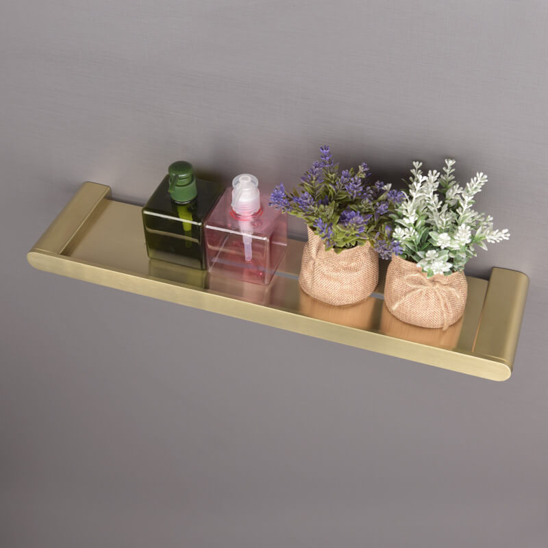 Gold floating shelf used as a plant holder, adding a touch of greenery to the bathroom space.