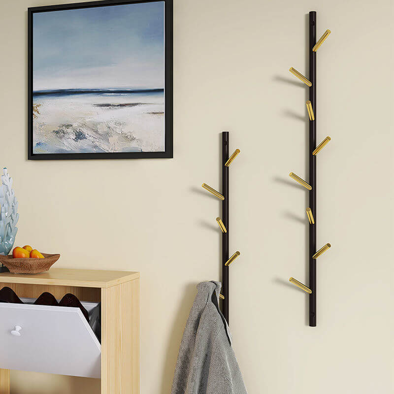Elegant gold and black coat rack with hooks for jackets in a contemporary setting.