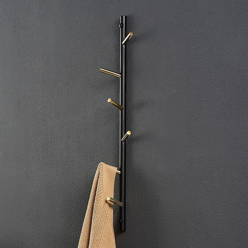 Overall view of the gold and black coat rack installed in a stylish entryway.