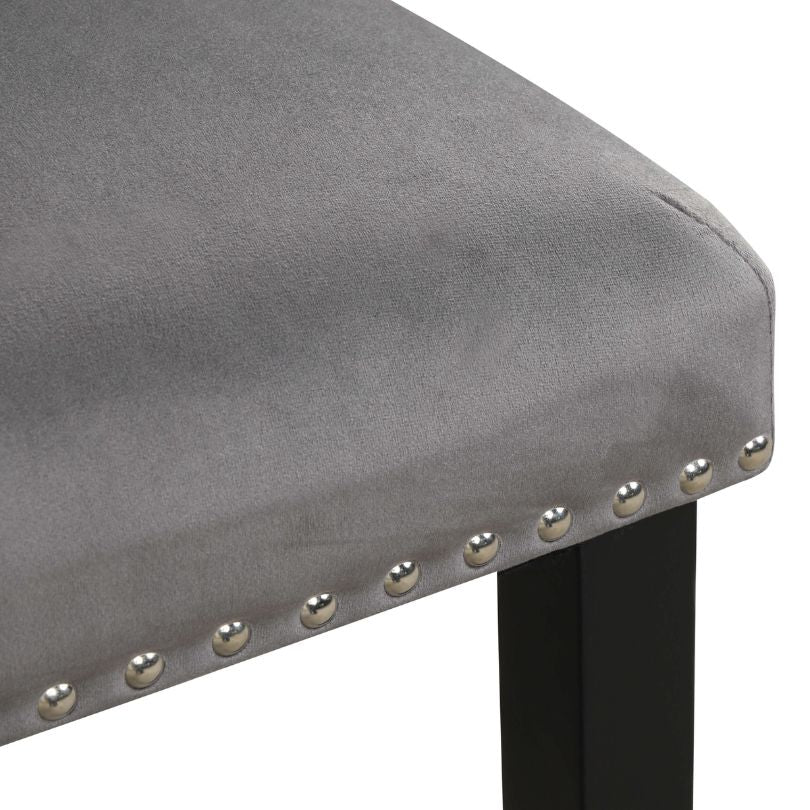 Contemporary dining chairs with nailhead trim arranged around a stylish dining table.