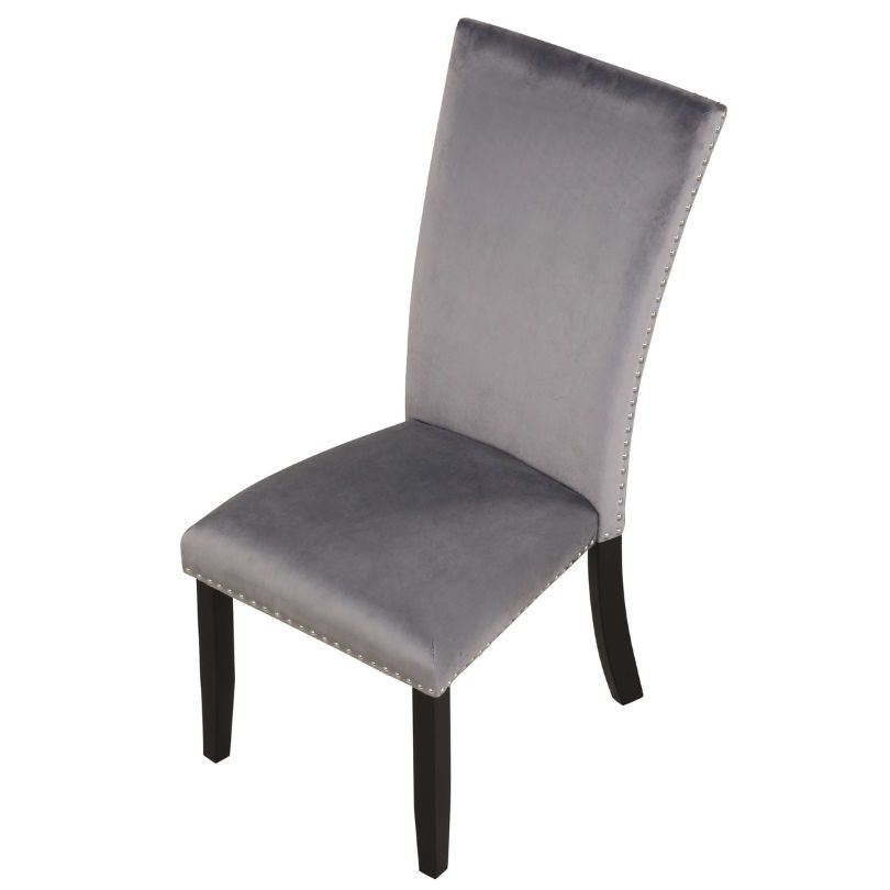 Contemporary dining chairs with nailhead trim arranged around a stylish dining table.