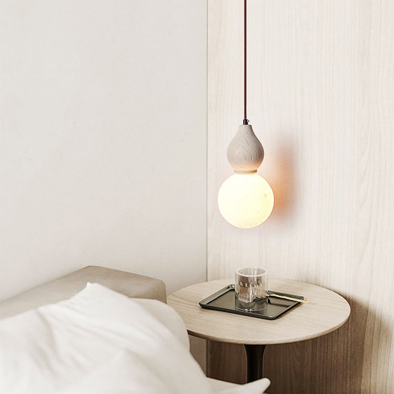 The pendant light installed in a cozy bedroom setting, demonstrating its vibrant illumination.