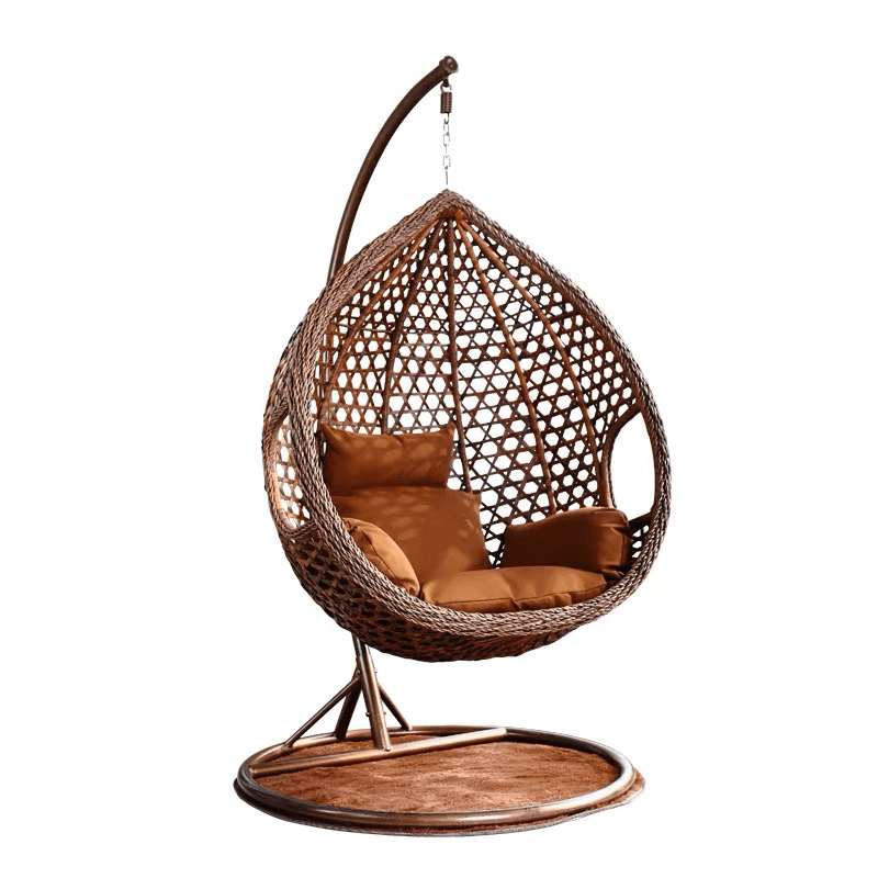 a person relaxing in the hanging rattan swing chair, enjoying a sunny patio