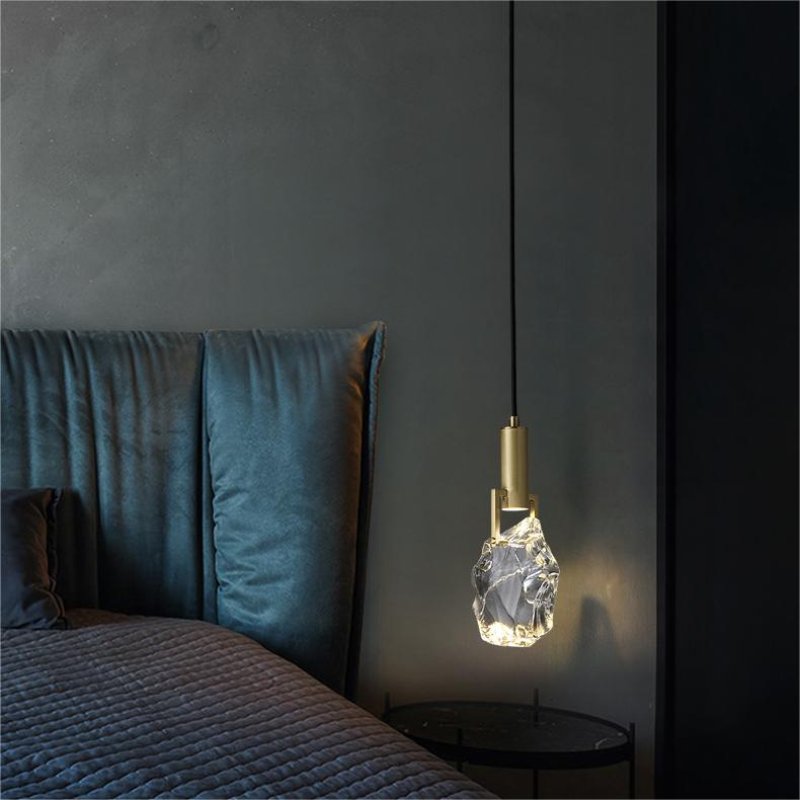 Elegant crystal pendant light illuminating a modern bedroom setting.