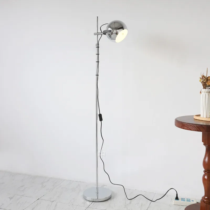 The Modern Chrome Bauhaus LED Floor Lamp illuminating a minimalist office space.