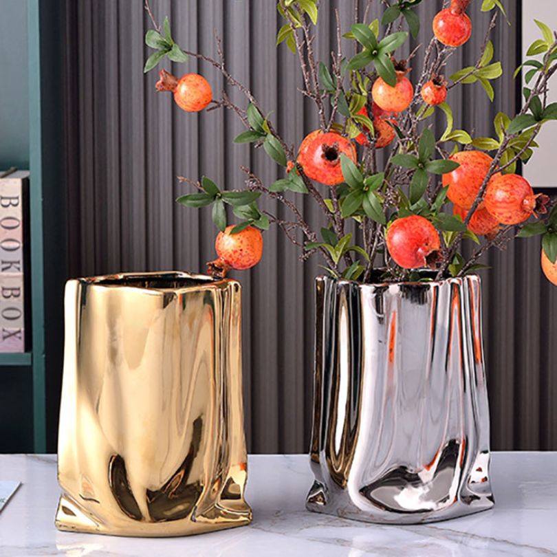 Ceramic vase displayed on a dining table with flowers.