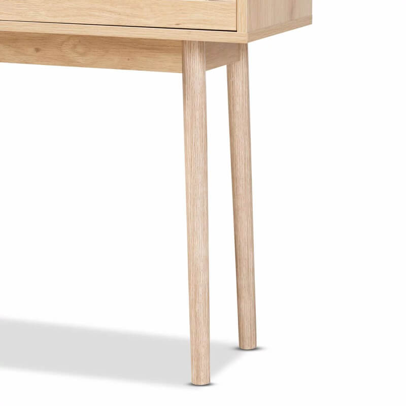 Side angle of the light oak console table displaying rattan drawers and gold-tone metal handles.