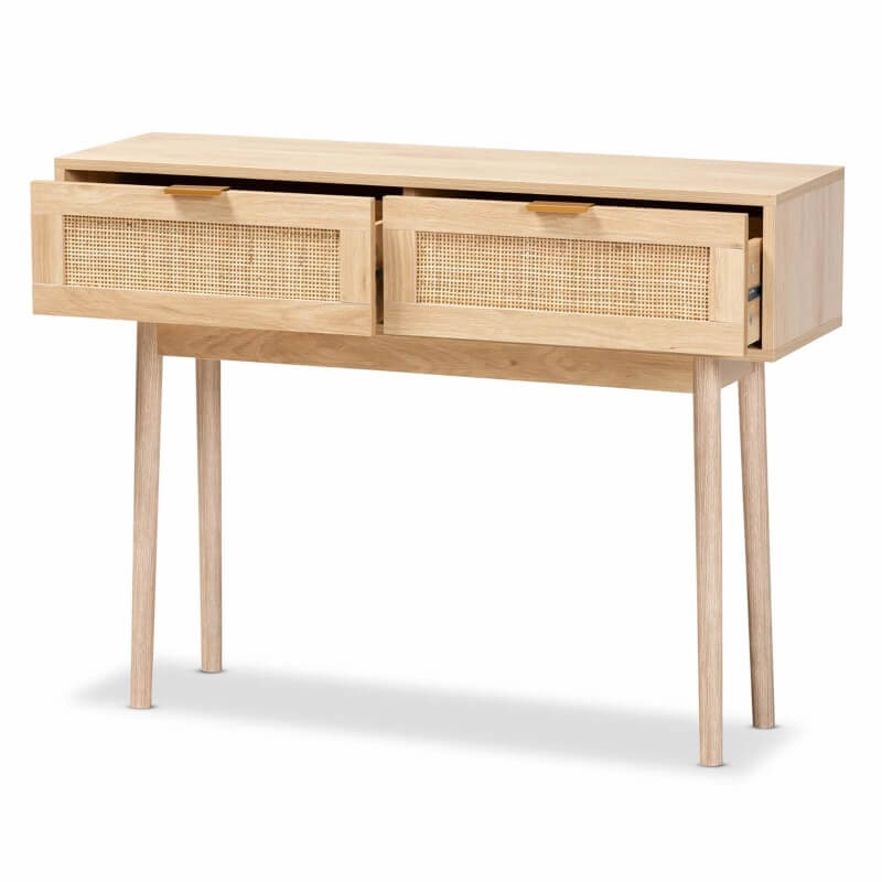 Side angle of the light oak console table displaying rattan drawers and gold-tone metal handles.