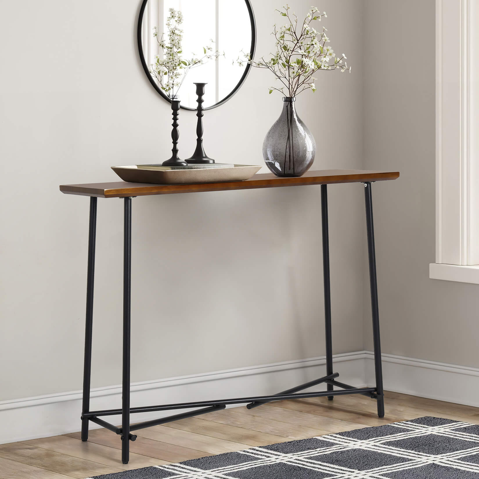 Long console table in an entryway with keys and magazines placed on it