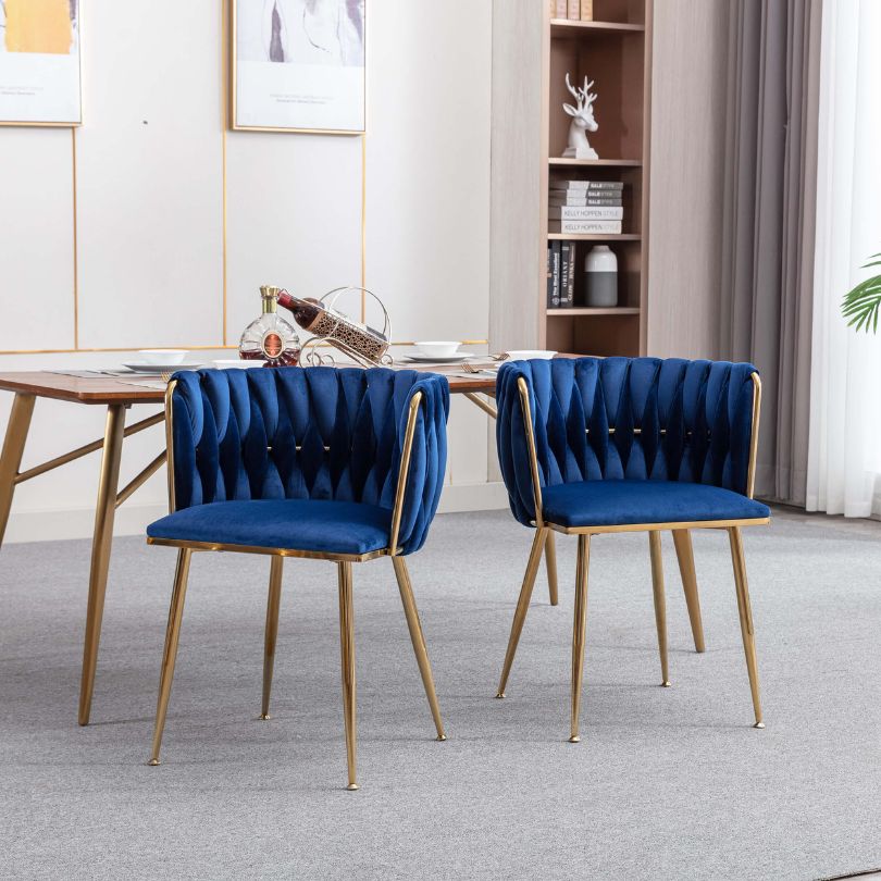 Stylish blue velvet dining chair positioned at a beautifully set dining table.