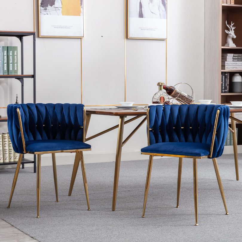 Elegant blue velvet dining chair featuring gold legs from the side view, perfect for dining rooms.