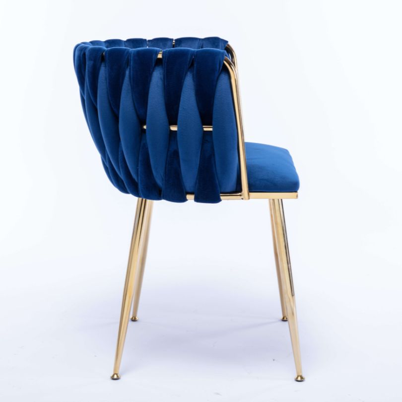 Close-up of the luxurious blue velvet fabric and golden legs of the dining chair.