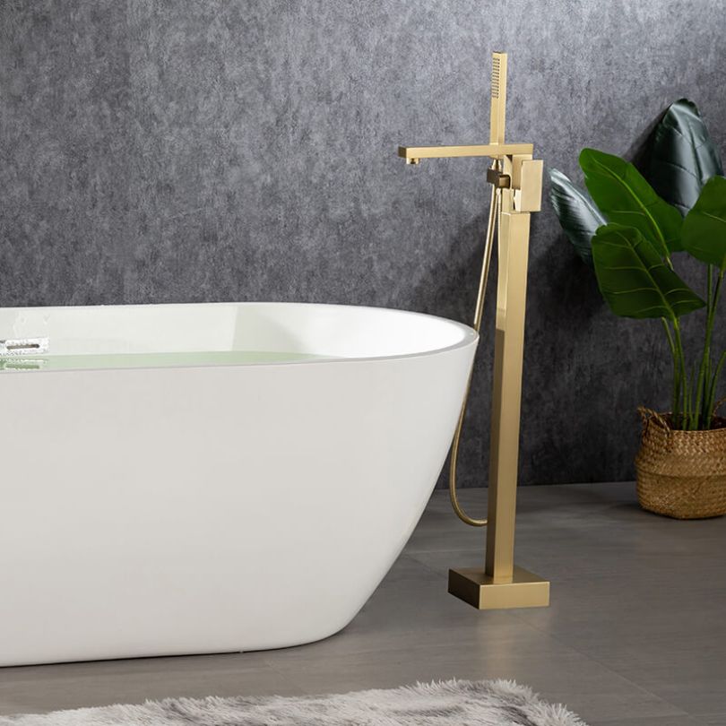 Close-up of the elegant gold freestanding bathtub mixer faucet with hand shower.