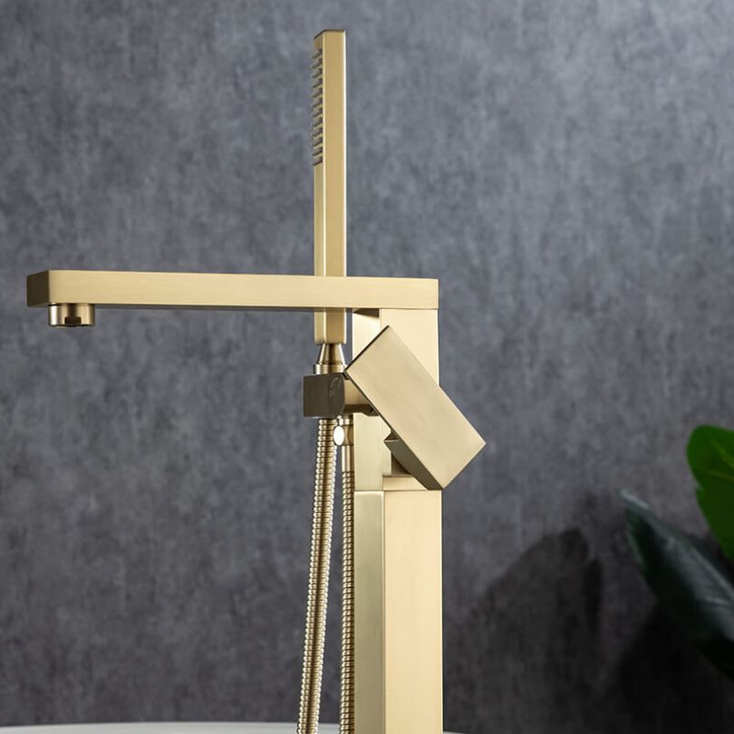 Luxurious brushed gold bathtub faucet installed in a stylish modern bathroom.