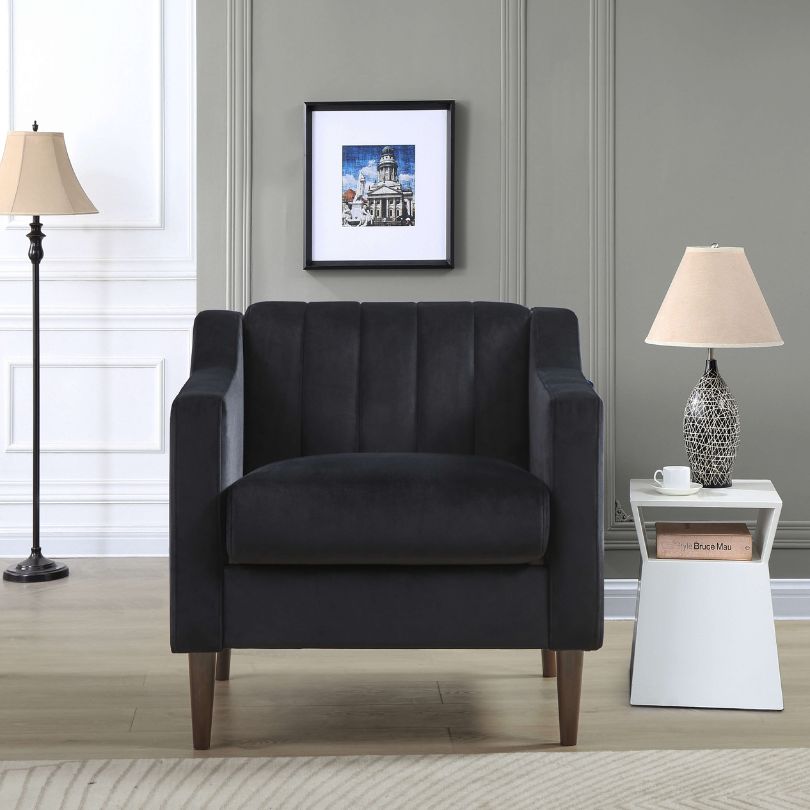 Front view of stylish black tufted barrel accent chair with wooden legs.
